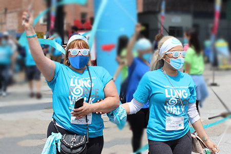two women waving ribbons at a LUNG FORCE Run/Walk