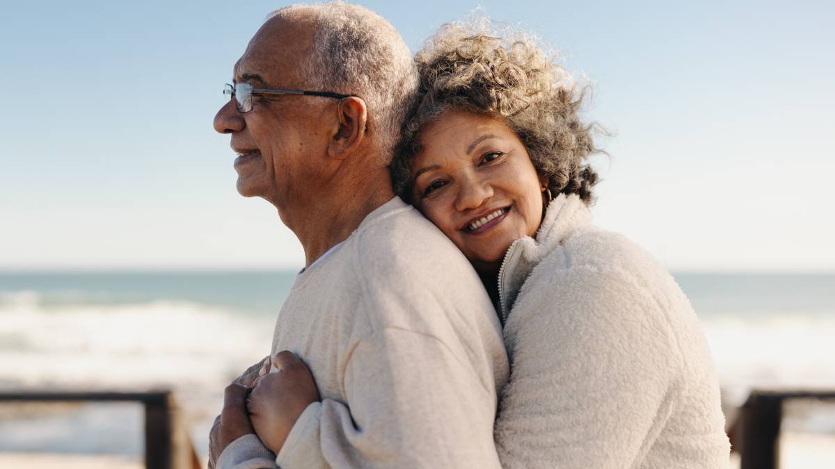 older couple hugging and smiling outdoors